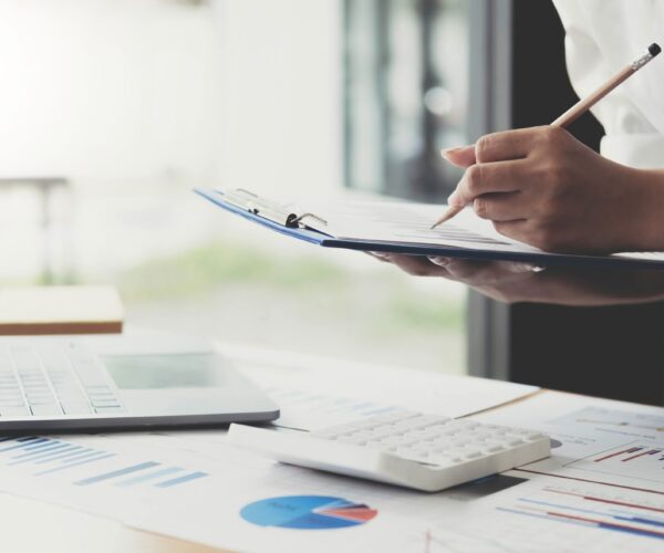 auditing company,business women financial inspector secretary do report about calculating,checking balance. Internal Revenue Service inspects checks document with a laptop computer and calculator..