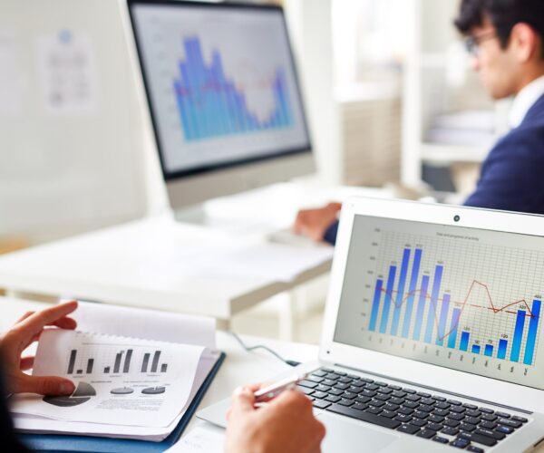 Statistics chart on laptop display and trader analyzing the data
